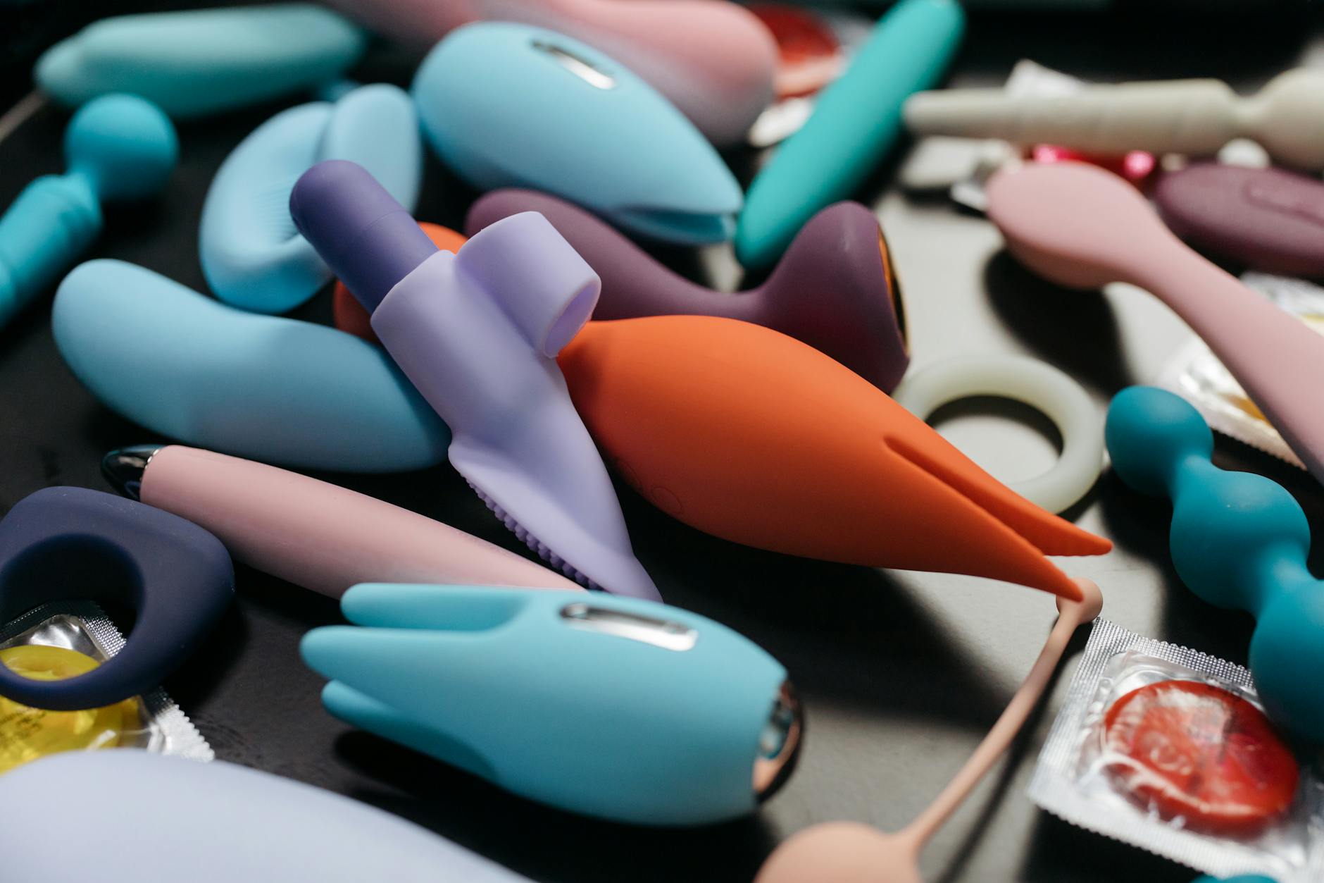 A blue silicone vibrator held in hand against a purple background, symbolizing self-care and pleasure during recovery