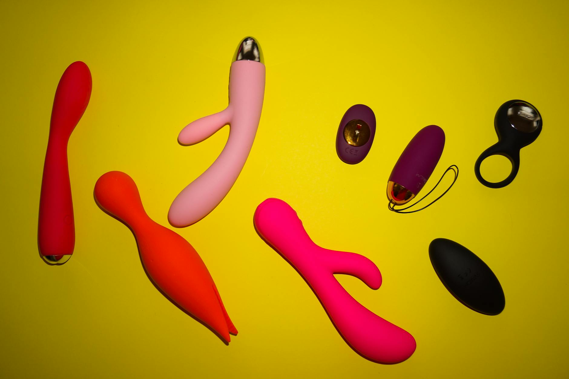 Vibrant arrangement of colorful clitoral vibrators on a bright yellow background
