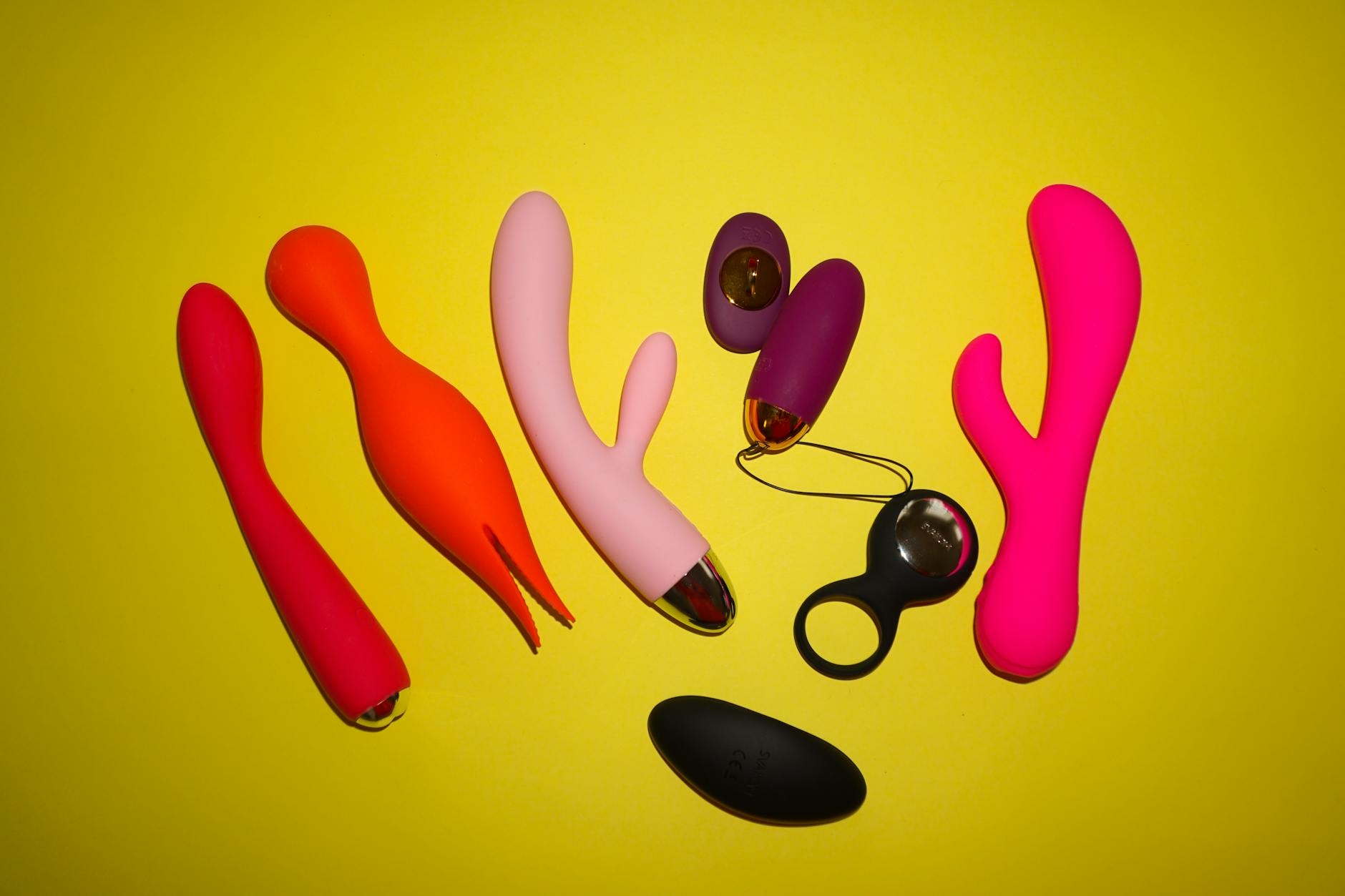 Hand holding a vibrator against a minimalist purple backdrop, showcasing modern sensuality
